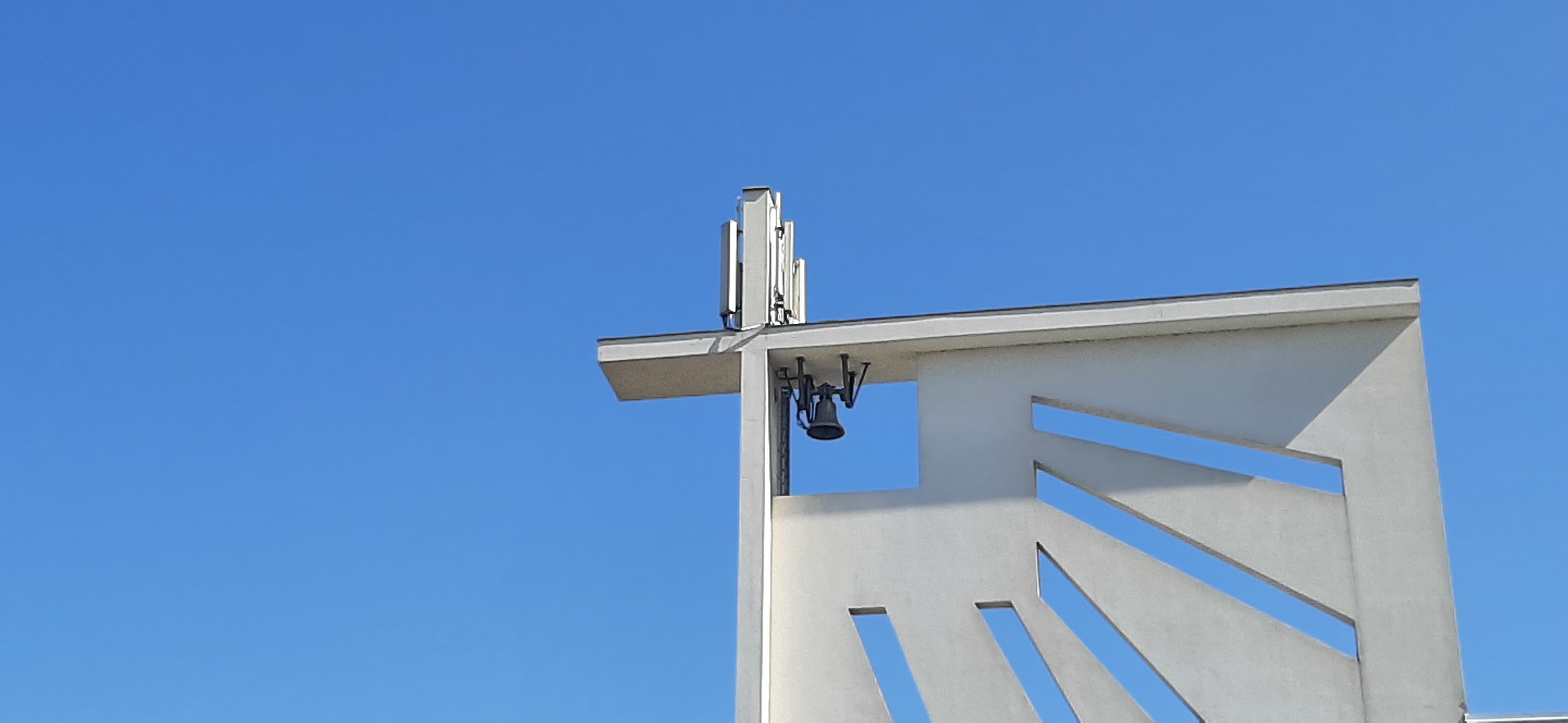 a church bell in front of a pure blue sky