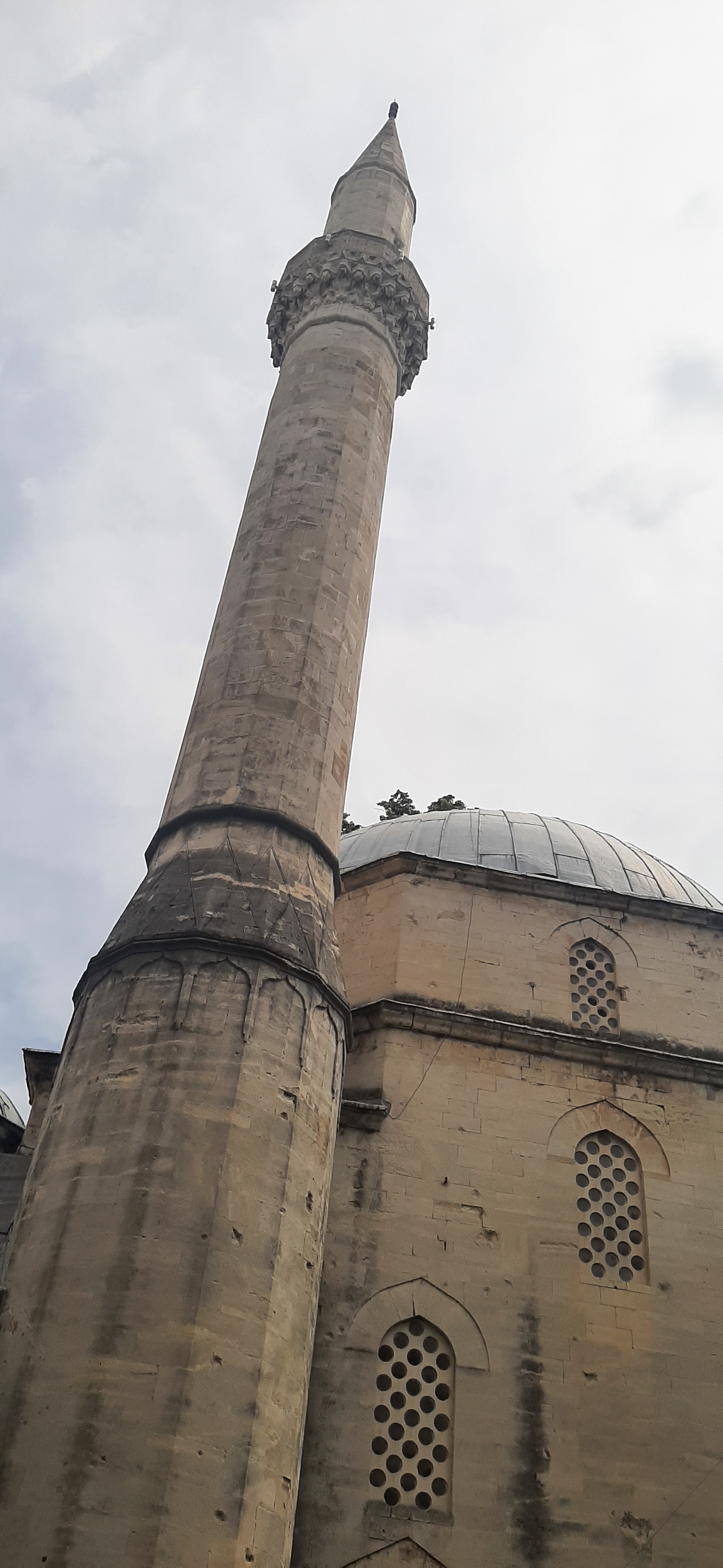 a mosque's tower in front of a gray sky